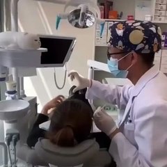 Une patiente de dentiste tente de faire un cœur avec sa main et son dentiste