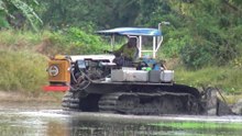 Thai farmer tractor plowing rice field Thailand