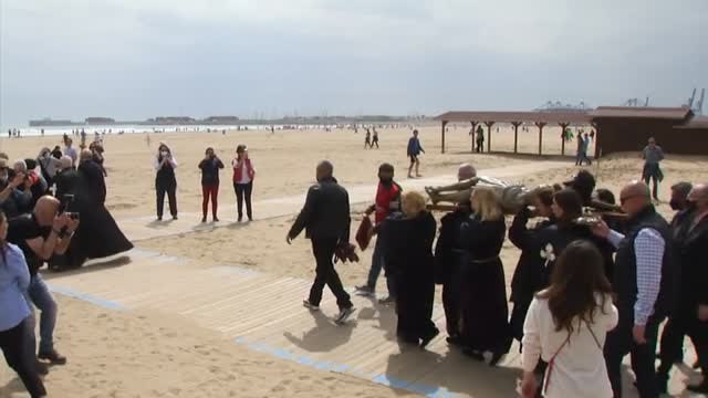 El Cristo del Salvador acude a la playa de la Malvarrosa en procesión con bañistas de por medio