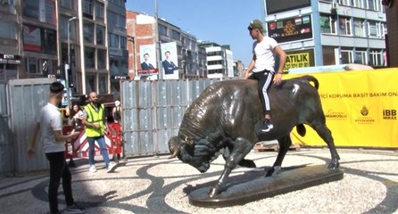 Bariyerleri aşıp bakıma alınan Boğa Heykeli’nin üzerine çıktı