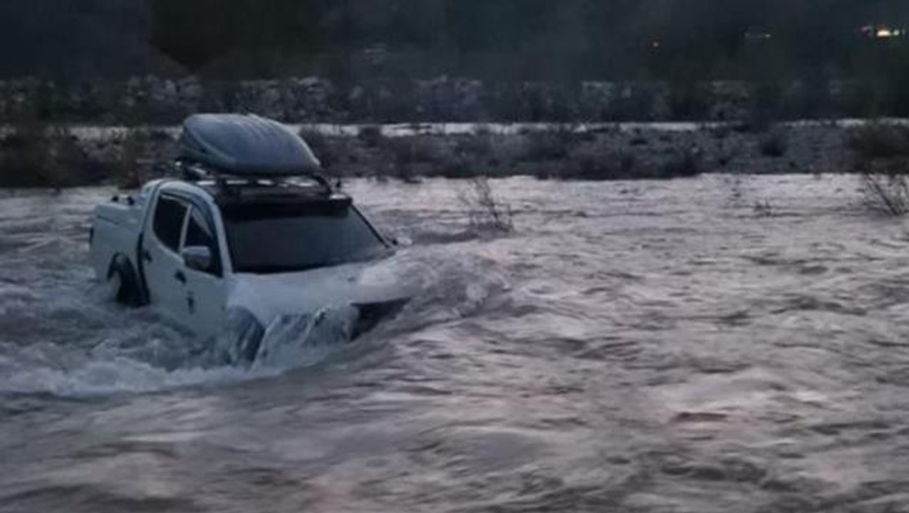 Aracıyla dere yatağından geçtiği sırada baraj kapakları açılınca debisi yükselen suyun ortasında kaldı