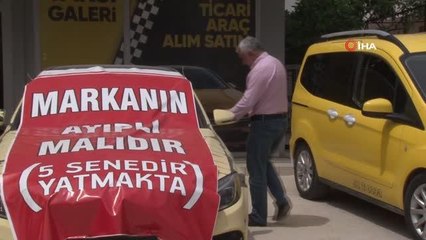Aldığı lüks aracı işyerinin önüne koyup, üzerine "Markanın ayıplı malıdır, 5 yıldır yatmakta" yazdı