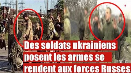 Des soldats ukrainiens déposent les armes aux pieds des forces Russes.