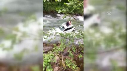 Dereye düşen otomobildeki çift, aracın üzerine çıkarak kurtuldu