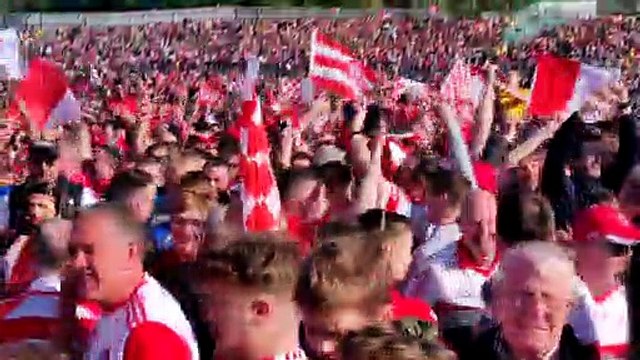 Derry players and fans celebrate Derry's Ulster Championship victory on the Clones pitch after the game