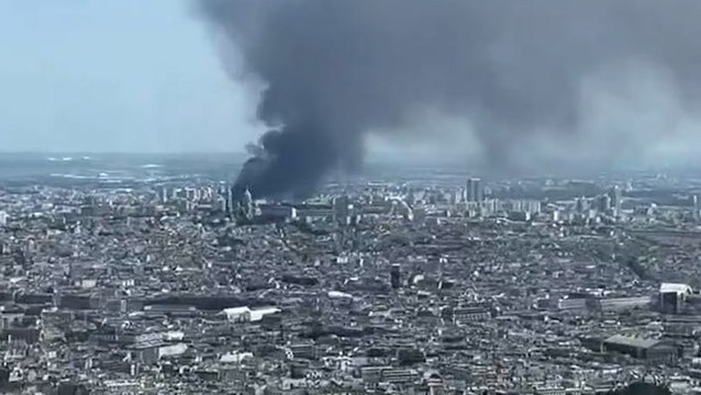 Tourist standing at top of Eiffel Tower captures smoke billowing from Paris fire