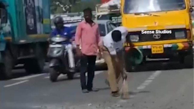 Image of the day: Traffic cop sweeps pebbles off the road in Tamil Nadu