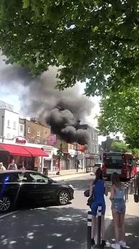 Police officer bravely runs into burning shop to rescue people. Credit: Amedé Unuabona