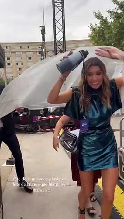 Laury Thilleman évite d'abîmer sa robe sous la pluie à Montpellier, lors de la Fête de la Musique, le 21 juin 2022.