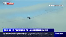 Le funambule Nathan Paulin s'assoit sur sa sangle au milieu de sa traversée de la Seine