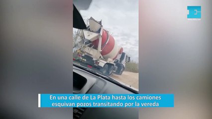 En una calle de La Plata hasta los camiones esquivan pozos transitando por la vereda