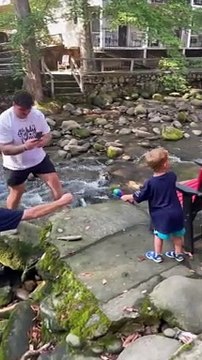 Un raton-laveur vient voler le poisson que vient de pêcher cet enfant