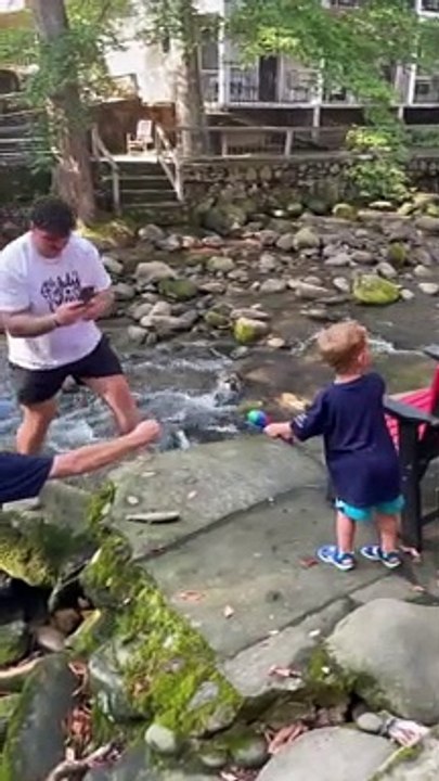 Un raton-laveur vient voler le poisson que vient de pêcher cet enfant