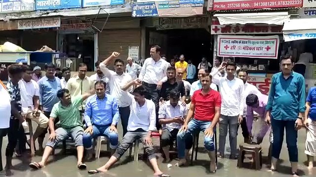पानी भराव से तीन दिन से व्यापार ठप्प, आक्रोशित व्यापारियों ने बरसाती पानी में बैठकर जताया आक्रोश