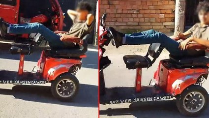 Motosikletini dakikalarca ayağıyla sürdü, kendisini çeken kameraya ise hiç aldırmadı