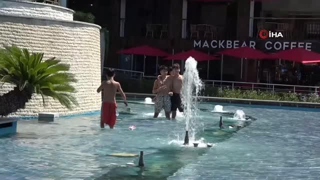 Sıcaktan bunalan çocuklar süs havuzunda serinledi