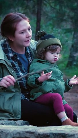 mother with her little daughter eating a marshmallow in nature and nurture