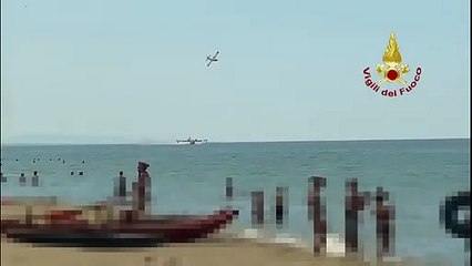 Incendio di Bozzano, il Canadair fa il pieno d'acqua davanti ai bagnanti