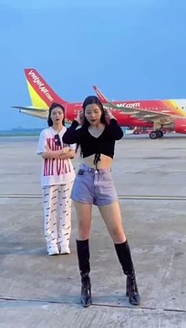 Hai cô gái nhảy nhót tại sân bay