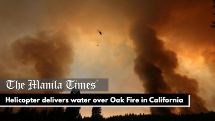 Helicopter delivers water over Oak Fire in California