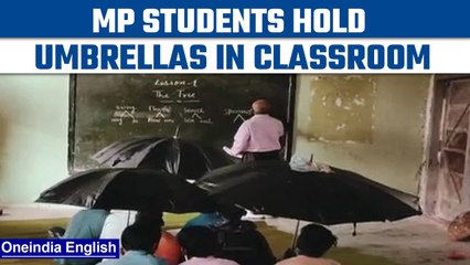 MP: Tribal students hold umbrellas in classroom as roof leaks in school | Oneindia News *viralvideo