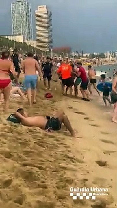 Agentes de la Guardia Urbana rescatan a un hombre en la playa
