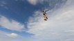 Skydivers Jump Through Clouds Over Scenic Landscape