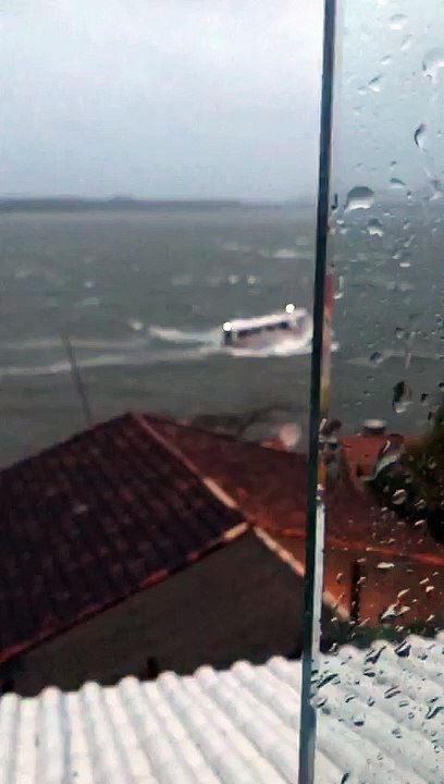 Barco navega durante ciclone na Costa da Lagoa, em Florianópolis