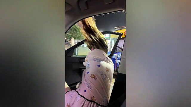 Elle n'arrive pas à fermer la porte de la voiture à cause du vent