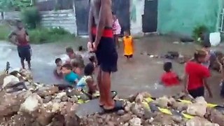 Niños improvisan una piscina en un bache en La Habana