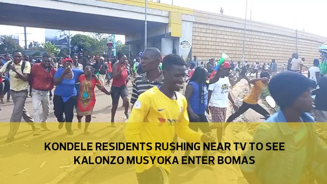 Kondele residents rushing to a nearby TV screen after they received information that Kalonzo Musyoka was making his way to Bomas
