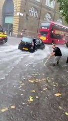 Homem tenta controlar cheias em Londres... com uma vassoura