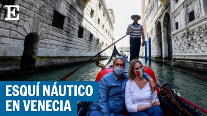 Dos personas recorren las calles de Venecia haciendo esquí acuático