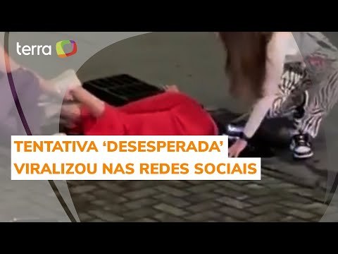 Mulher se pendura em bueiro para resgatar iPhone e cena viraliza nas redes sociais