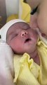 newborn baby preciously smiles when kissed