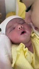 newborn baby preciously smiles when kissed
