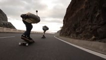 Skateboarder Duo Skates Downhill on Empty Road
