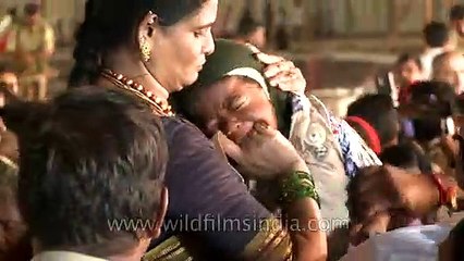 Force feeding raw fish to a baby in Hyderabad, India