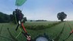 Guy Flies Paraglider Close to the Ground and Between Trees in Wide Open Field