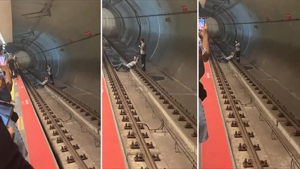 Duraktan metro raylarına atladı; ellerinin başının arkasına koyup raylarda uzandı