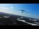 FPV Drone Captures Person Flying Hang Glider Above Frozen Lake
