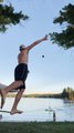 Guy Catches and Throws Football While Balancing Himself Over Slackline on Beach