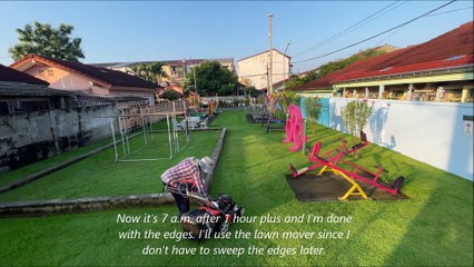 Cutting grass at children's playground in Thailand