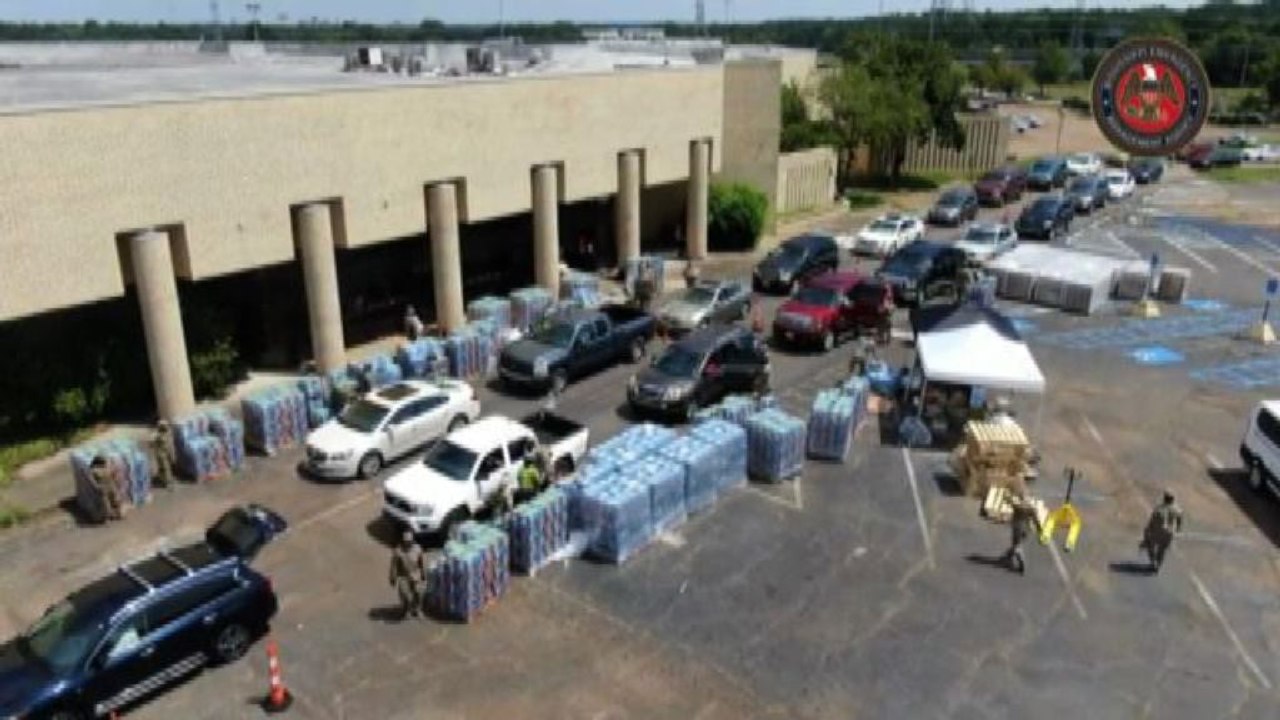Lunghe file di auto per ricevere casse d'acqua in Mississippi