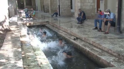 Sıcaktan bunalan çocuklar süs havuzlarında serinledi