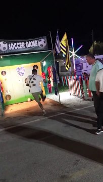 Guy Kicking Soccer Ball au Carnival Game Misses the Mark - Buzz Buddy