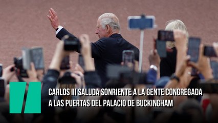 Carlos III saluda sonriente a la gente congregada a las puertas del palacio de Buckingham