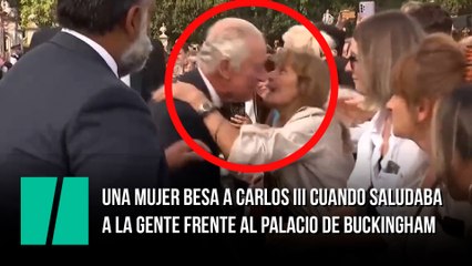 Una mujer besa a Carlos III cuando saludaba a la gente frente al palacio de Buckingham