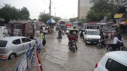Karaçi şehri sakinleri muson yağmurlarının ardından caddelerde güçlükle yürüyor