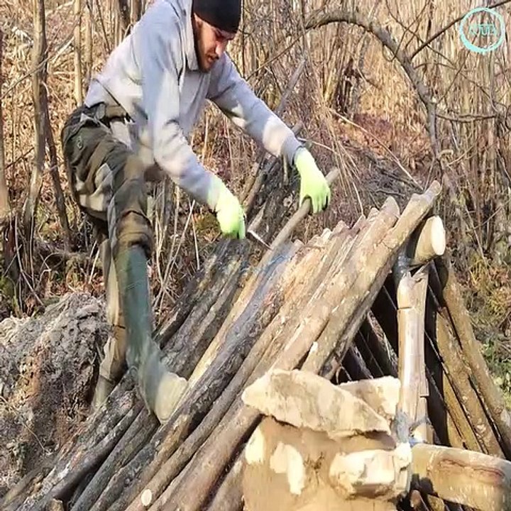 Building a survival house in the forest with improvised means during a weekend camping trip